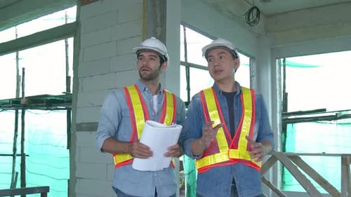 Construction Engineers Discuss Plans on Building Site