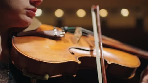 Closeup View of Old Violin in Hands of Female Musician During Concert in Music Hall