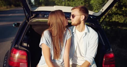 Couple Relaxing by Car on Countryside Road Trip