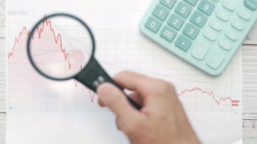 A Businessman Investor is Analyzing a Paper Graph of Bear Market with Magnifier
