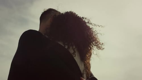 Couple Embracing in Loving Affection Under Bright Sky