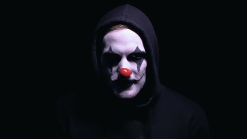 Hooded Figure with Clown Makeup Rubs Hands