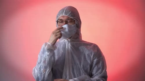 Young Adult Removing Mask in Protective Coverall