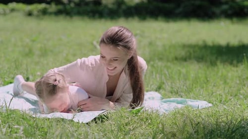 Family Time. Mother And Daughter Resting On Blanket At Park