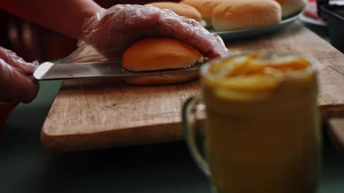 Chef Cuts Buns with Knife on Cutting Board