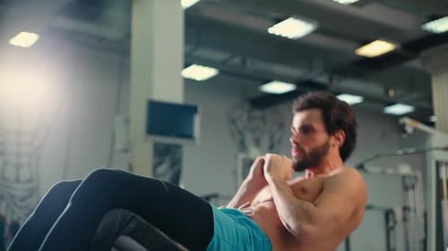 Man Doing Crunches in Brightly Lit Modern Gym
