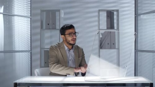 Geschäftsmann aus dem Nahen Osten arbeitet am Computer mit transparentem Display