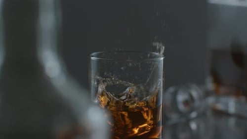 Ice Cube Dropped Into Glass Of Whiskey