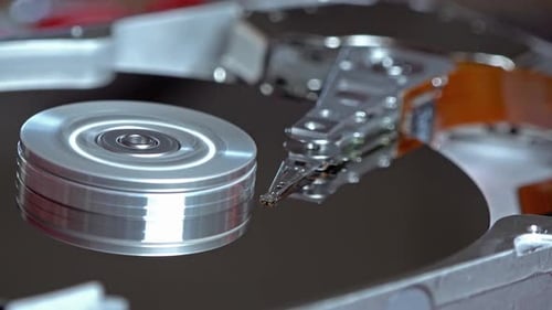 Nahaufnahme einer Festplatte eines Betriebscomputers beim Lesen und Schreiben von Daten