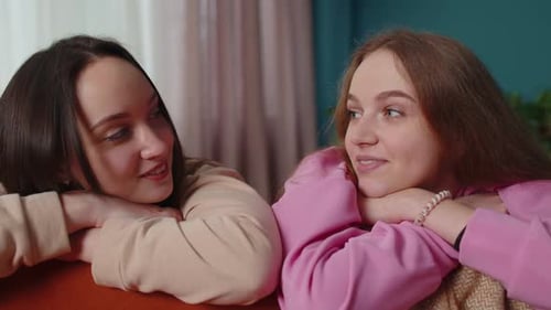 Two Young Women Talking Together Indoors Smiling