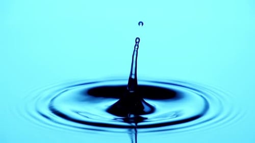 Water Drop Hits Pool Surface Creating Ripples
