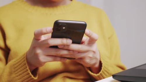 Close up hands Asian female sitting on desk reading replying phone message.