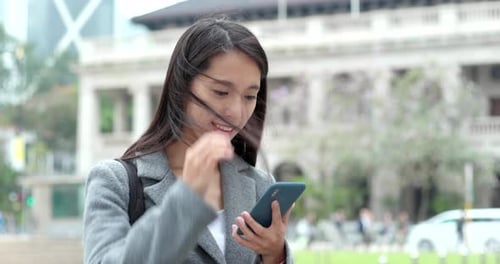 Asian Woman use of cellphone in city