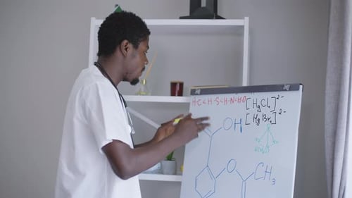 Man Teaching Chemistry Lesson at Whiteboard