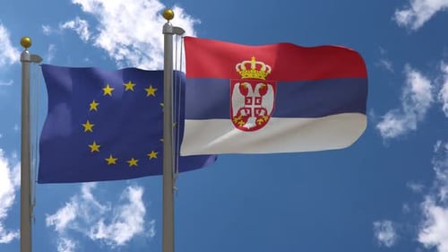 European Union and Serbian Flags Waving Against Blue Sky