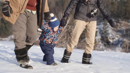 Happy Family Walking Together in Winter Snow