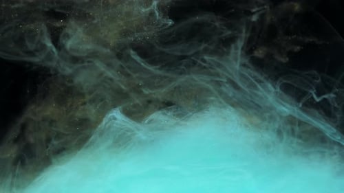 Türkisblaue und goldene Tintenfarbe mischen sich im Wasser und wirbeln sanft unter Wasser