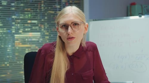 Portrait View of Blonde Woman in Eyeglasses Speaking to the Camera