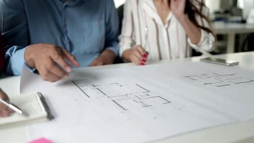 Team Collaboration Reviewing Architectural Blueprints in Office
