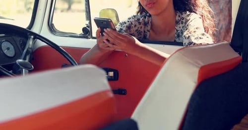 Young Woman Using Phone While Sitting in Van