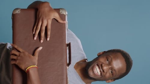 Man Holding Vintage Suitcase Laughing