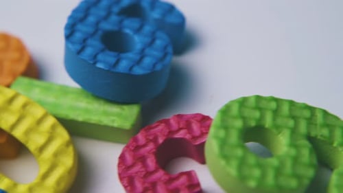 Foam Numbers Scattered on White Surface