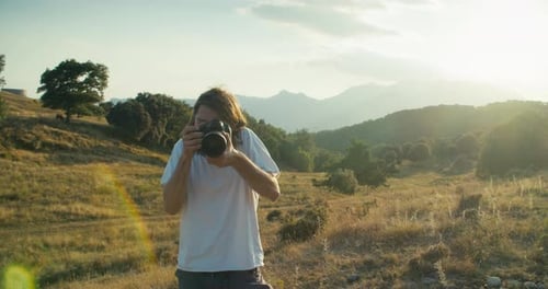 Creative Man Using Digital Camera to Make Photo on Summer Mountain Journey