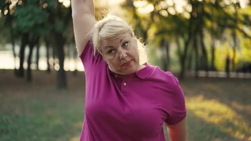 Dicke Frau macht Übungen im Park