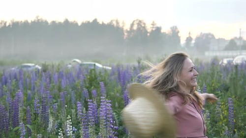 Lady with Hat Turns Around Spending Time in Lupin Field