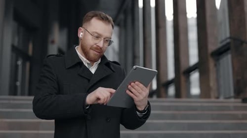 Businessman Using Tablet Device at Street