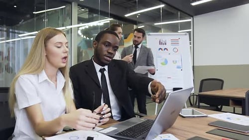 Diverse Team Working Together on Laptop in Office