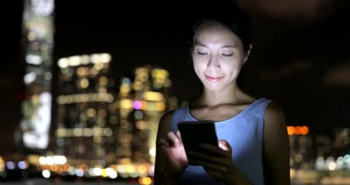 Woman using mobile phone at night