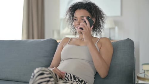 Woman Talking on Phone Sitting on Couch