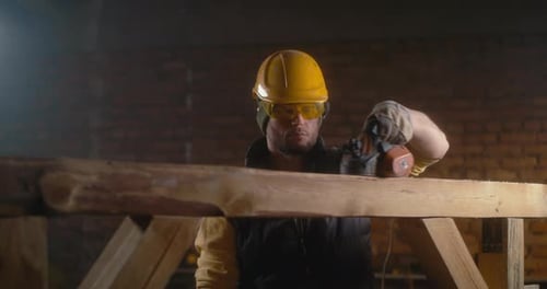 Man Cuts Wood With Power Tool in Workshop