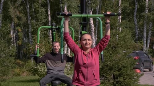 Man and Woman Doing Exercises in Outdoor Gym