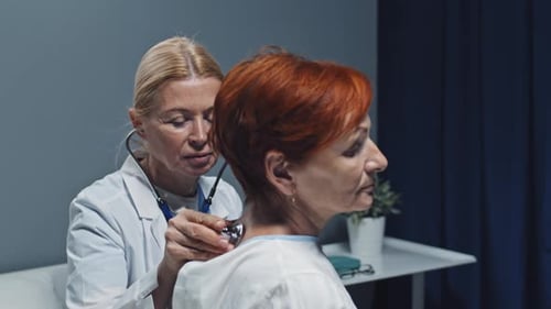Doctor Listens to Patient's Back with Stethoscope