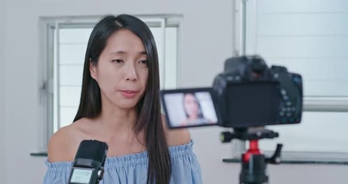 Woman Recording Vlog with Camera and Microphone