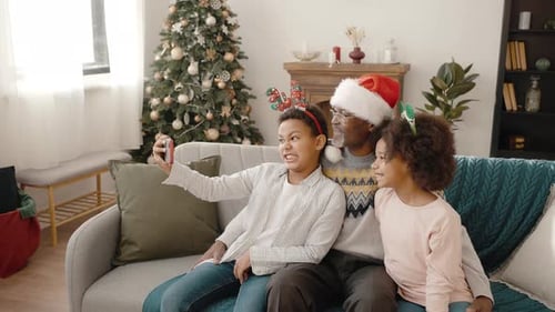 Grandfather and Grandchildren Taking Selfie at Christmas