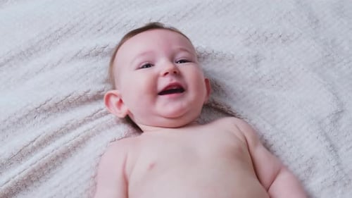 Happy Infant Smiling on Soft Blanket