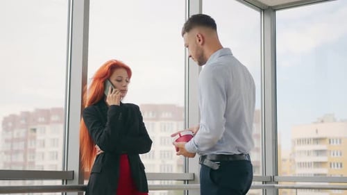 Man Surprises Woman with Gift in Modern Office