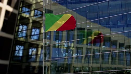 Congo National Flag Waving in Front of Modern Office Building