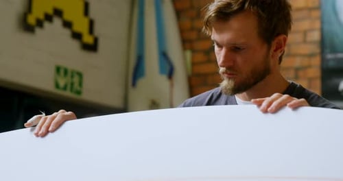 Man examining a surfboard