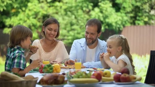 Family Enjoying Pizza and Lunch Outdoors