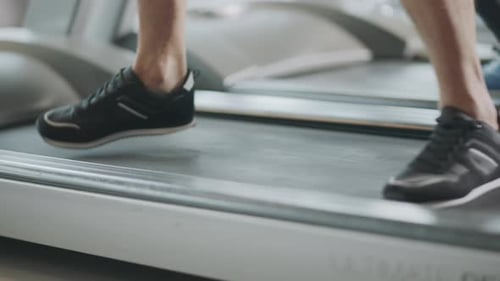 Closeup Feet Moving on Treadmill in Fitness Gym