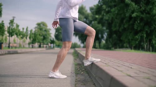 Woman Exercising Outdoors on Sidewalk in Park