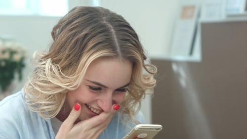 Woman Laughing While Using Her Mobile Phone