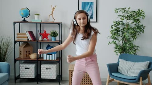 Happy Teen Girl Dancing to Music at Home