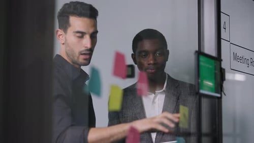 Manager aus dem Nahen Osten und Afroamerikanern diskutieren Haftnotizen im Besprechungsraum mit