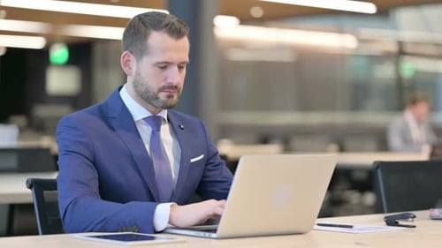 Middle Aged Businessman Working on Laptop in Office