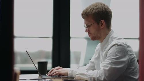 Adult Caucasian Man is Working in Office Typing Message in Laptop Keyboard Chatting in Work Chat